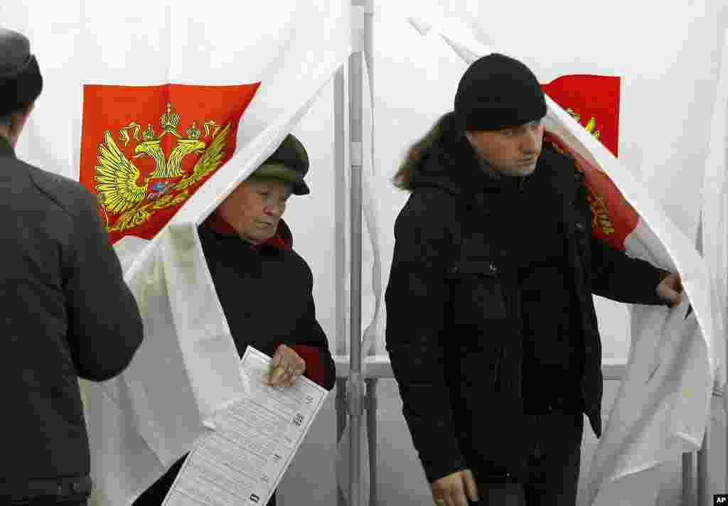 People leave voting booths at a polling station in the town of Roslavl, 390 kilometers (243 miles) west of Moscow, Russia, December 4, 2011. (AP)