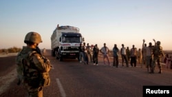 French soldiers search people at a checkpoint on the outskirts of Gao, Mali, February 14, 2013. 