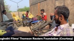 Pekerja Migran India yang mudik bersepeda di tengah lockdown akibat pandemi COVID-19 tahun 2020, beristirahat sejenak di tengah perjalanan mereka. (Foto: Bhagirathi Films/ Thomson Reuters Foundation)