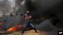 Palestinski demonstranti gađaju kamenicama izraelske vojnike za vreme sukoba na granici Gaze sa Izraelom. 