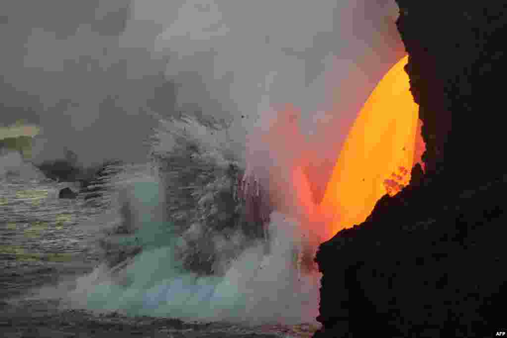 This image obtained from the U.S. Geological Survey&#39;s Hawaiian Volcano Observatory showing a lava stream, pouring out of the lava tube on the sea cliff at the Kamokuna ocean entry from the Kilauea Volcano, Hawaii, Jan. 29, 2017.