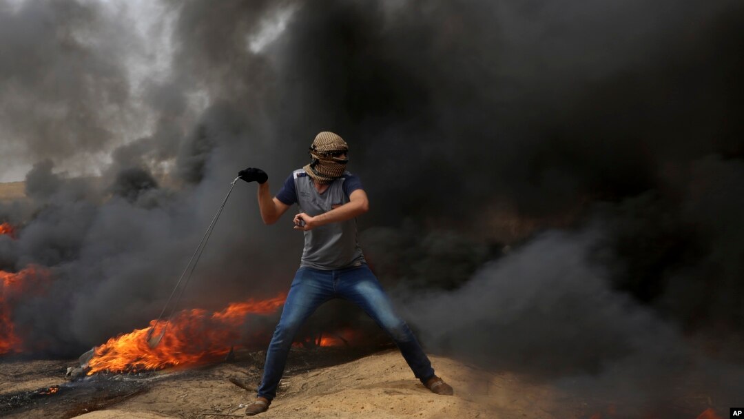 Palestinski demonstranti gađaju kamenicama izraelske vojnike za vreme sukoba na granici Gaze sa Izraelom. 
