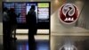 Pria berdiri di samping logo maskapai penerbangan Japan Airlines (JAL), di tengah wabah COVID-19, di Bandara Haneda di Tokyo, Jepang, 30 Oktober 2020. (Foto: REUTERS/Issei Kato)