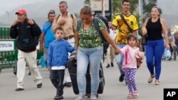 Venezuelan migrant mother Yelitza Fuenmayor crosses the Simon Bolivar International Bridge into Colombia with her children and luggage, to Cucuta, Colombia, as they leave Venezuela. 