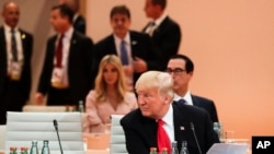 ប្រធានាធីបតី​អាមេរិក​លោក Donald Trump អង្គុយ​នៅ​ខាងមុខ​គនប្រតិភូ​ដែលជាកូនស្រី​របស់លោកគឺអ្នក​ស្រី​ Ivanka Trump នៅ​ពេល​ដែល​លោក​ចូល​រួម​ក្នុង​កិច្ច​ប្រជុំ​កំពូល​ G-20 ក្នុង​ទីក្រុង​ Hamburg ភាគ​ខាងជើង​ប្រទេស​អាល្លឺម៉ង់កាល​ពី​ថ្ងៃទី​០៨ កក្កដា​ ២០១៧។