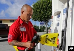 Albert Fernández, empleado de una estación de gasolina en Key Largo, Florida, pone un aviso de cierre de una estación de bombeo que se quedó sin combustible debido a la enorme demanda de residentes antes de la llegada del huracán Irma al estado. Septiembre 6, 2017.