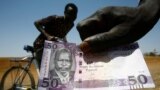 FILE - A South Sudanese man shows his country's 50-pound note, Feb. 28, 2017.