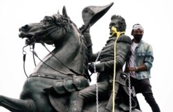 A protestor wraps chains and ropes around the statue of U.S. President Andrew Jackson during an attempt to pull the statue down in the middle of Lafayette Park in front of the White House during racial inequality protests in Washington.