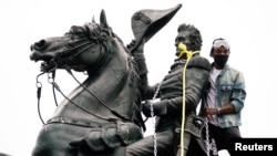 FILE - A protester wraps chains and ropes around the statue of President Andrew Jackson in Washington's Lafayette Park on June 22, 2020. U.S. President Donald Trump signed an executive order on Jan. 29, 2025, aimed at protecting monuments, memorials and statues from vandalism.