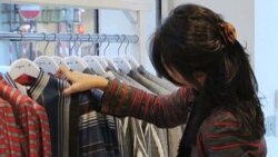 Afghan fashion designer Zolaykha Sherzad looks through clothing from her label Zarif Designs at a London boutique