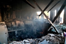 Smoke rises from the reception room of the U.S. Embassy that was burned by Pro-Iranian militiamen and their supporters, in Baghdad, Jan. 1, 2020.