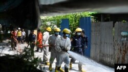 ရန်ကုန်မြို့တွင်း လမ်းတခုတွင် COVID-19 ကာကွယ်ဆေးဖြန်းနေသည့် မီးသတ်တပ်ဖွဲ့ဝင်များနဲ့ စေတနာ့ဝန်ထမ်းများ။ (ဧပြီ ၂၁၊ ၂၀၂၀)
