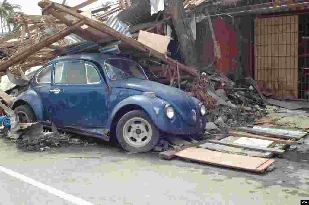 Most residents saw not only their homes destroyed but also their vehicles, Tacloban, Nov. 21, 2013. (Steve Herman/VOA)