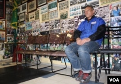Barber Louis de Hart waits for a customer under a wall of rare rugby photographs. (Darren Taylor for VOA News)