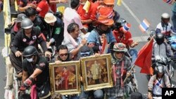 'Red Shirt' anti-government protesters, holding portraits of the Thai king and queen, leave their fortified camp in central Bangkok for a rally in the outskirts of the capital, 28 Apr 2010