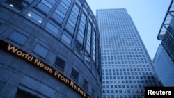 FILE - An electronic board displays the latest news outside Thomson Reuters headquarters at Canary Wharf in London, Jan. 26, 2017.