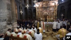 Catholics Christians pray in Church of the Holy Sepulchre, traditionally believed by many to be the site of the crucifixion of Jesus Christ, during Easter Sunday procession in Jerusalem's old city, April 21, 2019.