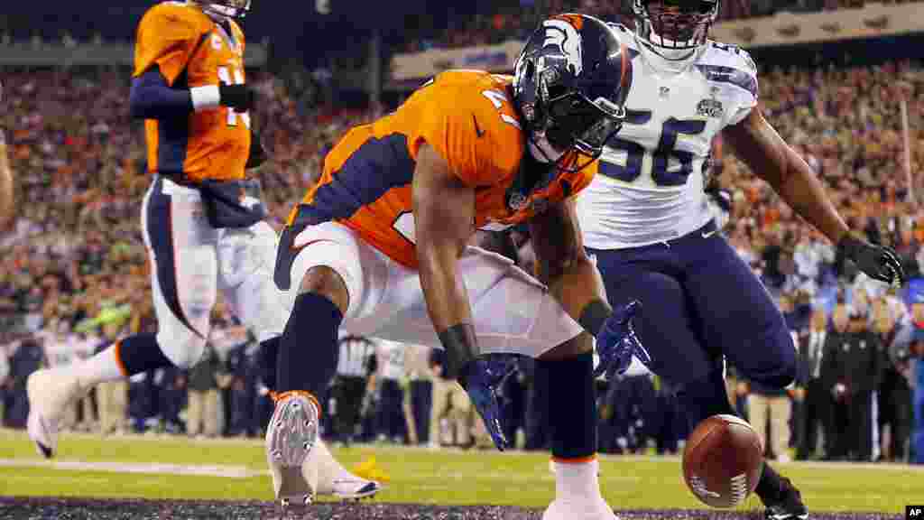 Denver Broncos&#39; Knowshon Moreno reaches for a loose ball after the snap passed teammate Peyton Manning, left, during the first half of the NFL Super Bowl XLVIII football game.