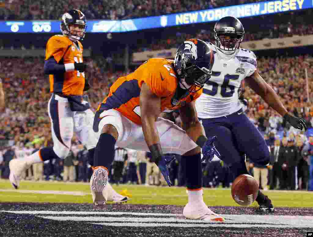 Denver Broncos' Knowshon Moreno reaches for a loose ball after the snap passed teammate Peyton Manning, left, during the first half of the NFL Super Bowl XLVIII football game, Feb. 2, 2014, in East Rutherford, N.J.