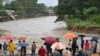 People look at a flooded creek near San Pedro Sula, Honduras, on Nov. 16, 2024.