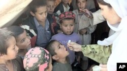 An Afghan refugee receives polio drops from a Pakistani nurse at the Shamshatu refugee camp near Peshawar. (File Photo)