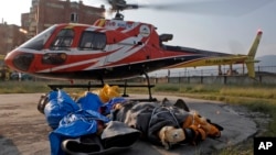 FILE - In this May 28, 2017 photo, the bodies of Indian climbers, that were retrieved from Mount Everest by a rescue team of eight sherpas, lay on the ground in Kathmandu, Nepal. 