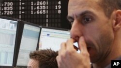 Traders watch their screens at the stock market in Frankfurt, Germany, Monday, Sept.12, 2011, when the German stock index DAX went down under 5000 points.