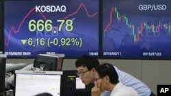 FILE - Currency traders work at the foreign exchange dealing room of the KEB Hana Bank headquarters in Seoul, South Korea, Wednesday, Sept. 2, 2015. 