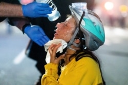 A medic treats Black Lives Matter protester Lacey Wambalaba after exposure to chemical irritants deployed by federal officers at the Mark O. Hatfield United States Courthouse, July 24, 2020, in Portland, Oregon.