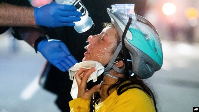 A medic treats Black Lives Matter protester Lacey Wambalaba after exposure to chemical irritants deployed by federal officers at the Mark O. Hatfield United States Courthouse, July 24, 2020, in Portland, Oregon.