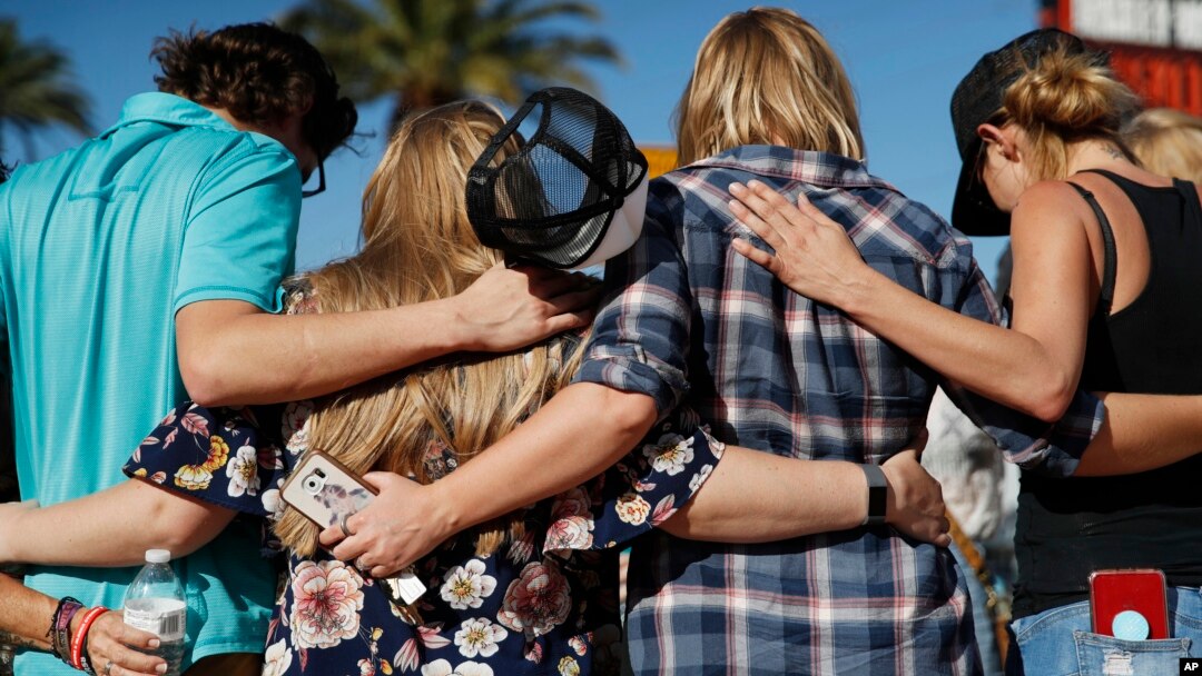 Un grupo de personas reza en un lugar de Las Vegas donde se realizó un tributo a las víctimas de la masacre del 1 de octubre de 2017 que asistían a un concierto de música country. Domingo, 30 de septiembre de 2018.