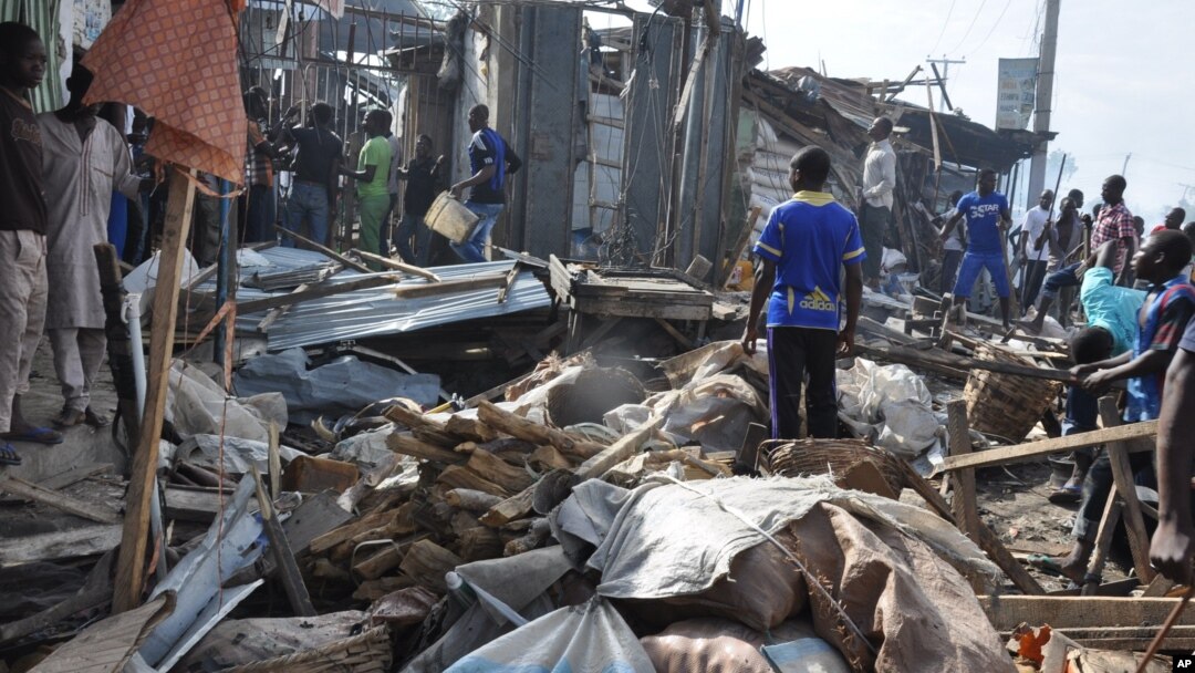 Warga memeriksa lokasi ledakan di Maiduguri, Nigeria, Selasa (1/7).