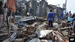 Warga memeriksa lokasi ledakan di Maiduguri, Nigeria, Selasa (1/7).