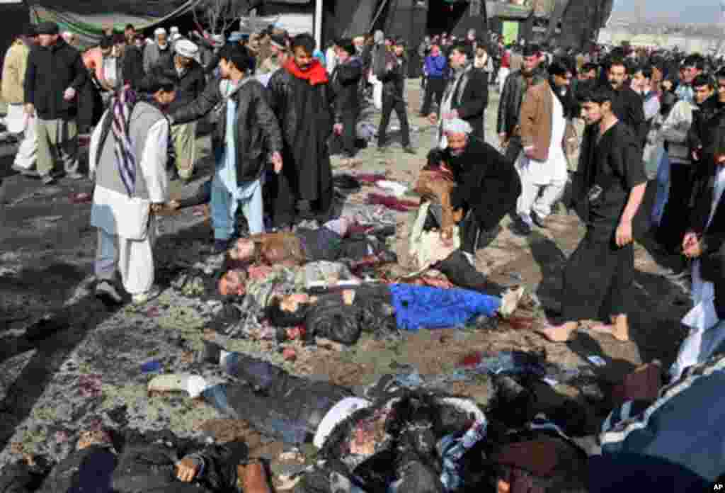 EDS NOTE: GRAPHIC CONTENT - Victims of a suicide attack which struck a Muharram procession lie on the ground in Kabul, Afghanistan, Tuesday, Dec. 6, 2011. A suicide bomber struck a crowd of Shiite worshippers marking a holy day Tuesday in the Afghan capit