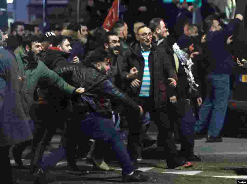 Para demonstran menghadapi polisi anti-huru-hara di luar konsulat Turki di Rotterdam, Belanda (12/3). (Reuters/Yves Herman)