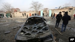 Người Afghanistan đứng gần hiện trường vụ đánh bom tự sát ở Kabul hôm 1/2.