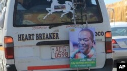 A portrait of Zimbabwe's President Emmerson Mnangagwa hangs from the back of a public transport vehicle on the streets of Harare, July, 27, 2018.