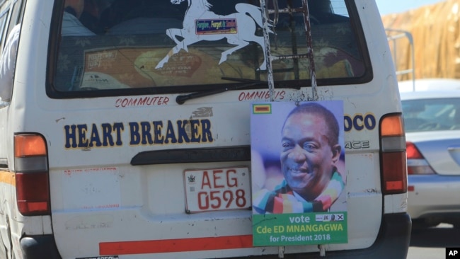 A portrait of Zimbabwe's President Emmerson Mnangagwa hangs from the back of a public transport vehicle on the streets of Harare, July, 27, 2018.