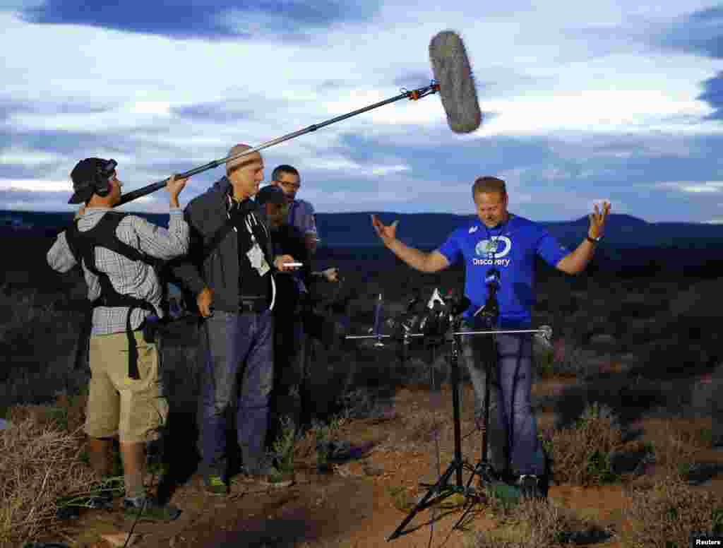 Daredevil Nik Wallenda gestures during a news conference after completing his tightrope walk across a chasm near the Grand Canyon.