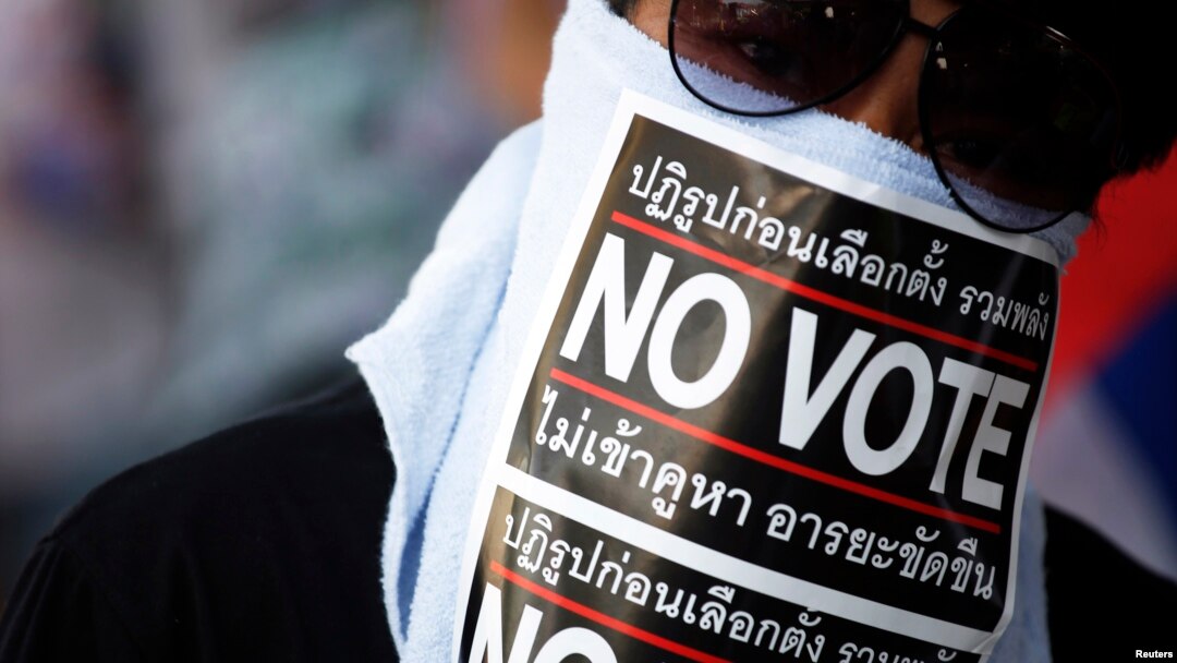 Seorang demonstran anti-pemerintah Thailand mengenakan masker bertuliskan "No Vote" saat melakukan pawai protes di Bangkok (31/1).