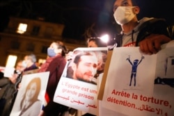 Human rights activists stage a protest over human rights violations in Egypt during a two-day official visit of Egyptian President Abdel Fattah al-Sisi in Paris, France, Dec. 8, 2020.