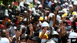 Anti-coup protesters flash the three-finger sign of resistance during a demonstration in Mandalay, Myanmar, March 6, 2021. 