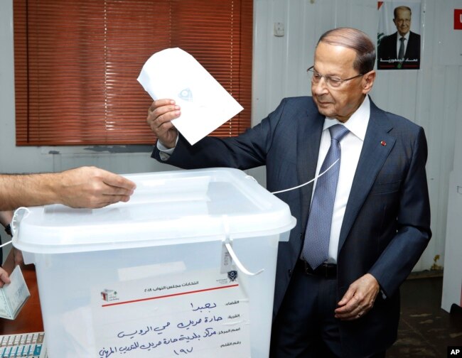 In this photo released by Lebanon's official government photographer Dalati Nohra, President Michel Aoun, casts his vote for Lebanon's parliamentary elections, at a ballot station, in the southern suburb of Beirut, May 6, 2018.