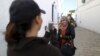 Falconer Maroua (L), for the price of a few dinars, photographs a woman as she poses with a falcon on her shoulder in Sidi Bou Said, a popular tourist destination near Tunis, Tunisia, Feb. 2, 2016.