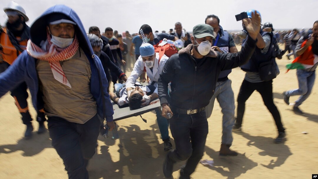 Abajejwe gutabara ba Palestina batwara urwaruka rwakomeretse mu myiyerekano yabereye mu karere ka Gaza, Itariki 14/05/2018. 