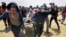 palestinski bolničari i demonstranti evakuiraju ozbiljno povrijeđenog mladića tokom smrtonosnog okršaja na granici sa Izraelom, Pojas Gaze, maj 14, 2018. 