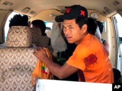 FILE - An injured man sits inside a vehicle in Muse, northern Shan state, Myanmar, May 12, 2018. Myanmar officials say an ethnic rebel group has launched an attack against the country’s military in the northern town.