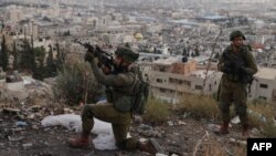 FILE - An Israeli soldier aims his rifle during a raid at the Balata camp for Palestinian refugees, east of Nablus in the occupied West Bank on Nov. 19, 2023.