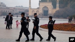 In this Nov. 4, 2017 photo, Uyghur security personnel patrol near the Id Kah Mosque in Kashgar in western China's Xinjiang region.(AP Photo/Ng Han Guan)