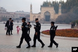 In this Nov. 4, 2017 photo, security personnel patrol near the Id Kah Mosque in Kashgar in western China's Xinjiang region.(AP Photo/Ng Han Guan)